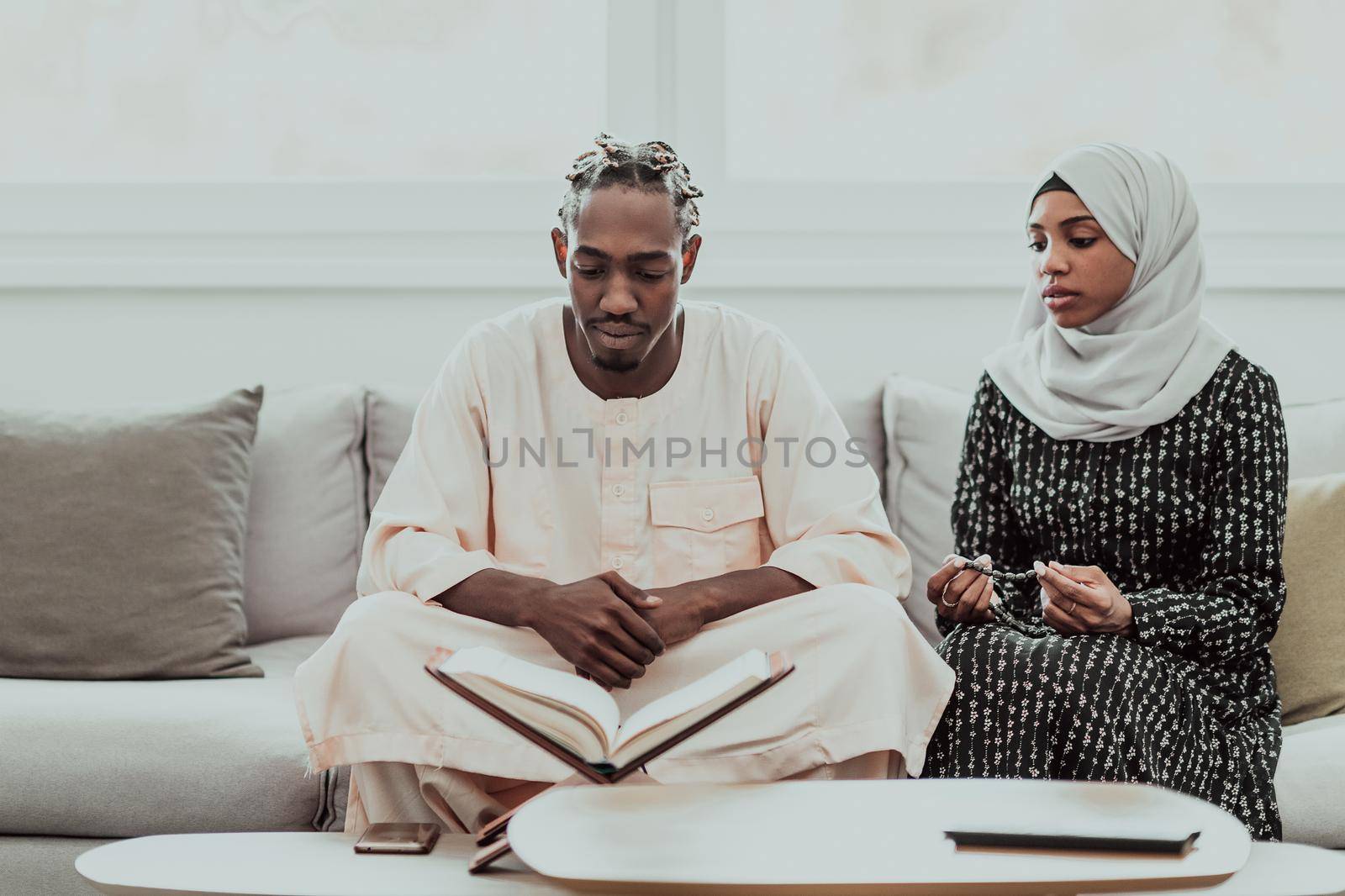 African Muslim couple at home in Ramadan reading Quran holly Islam book. by dotshock