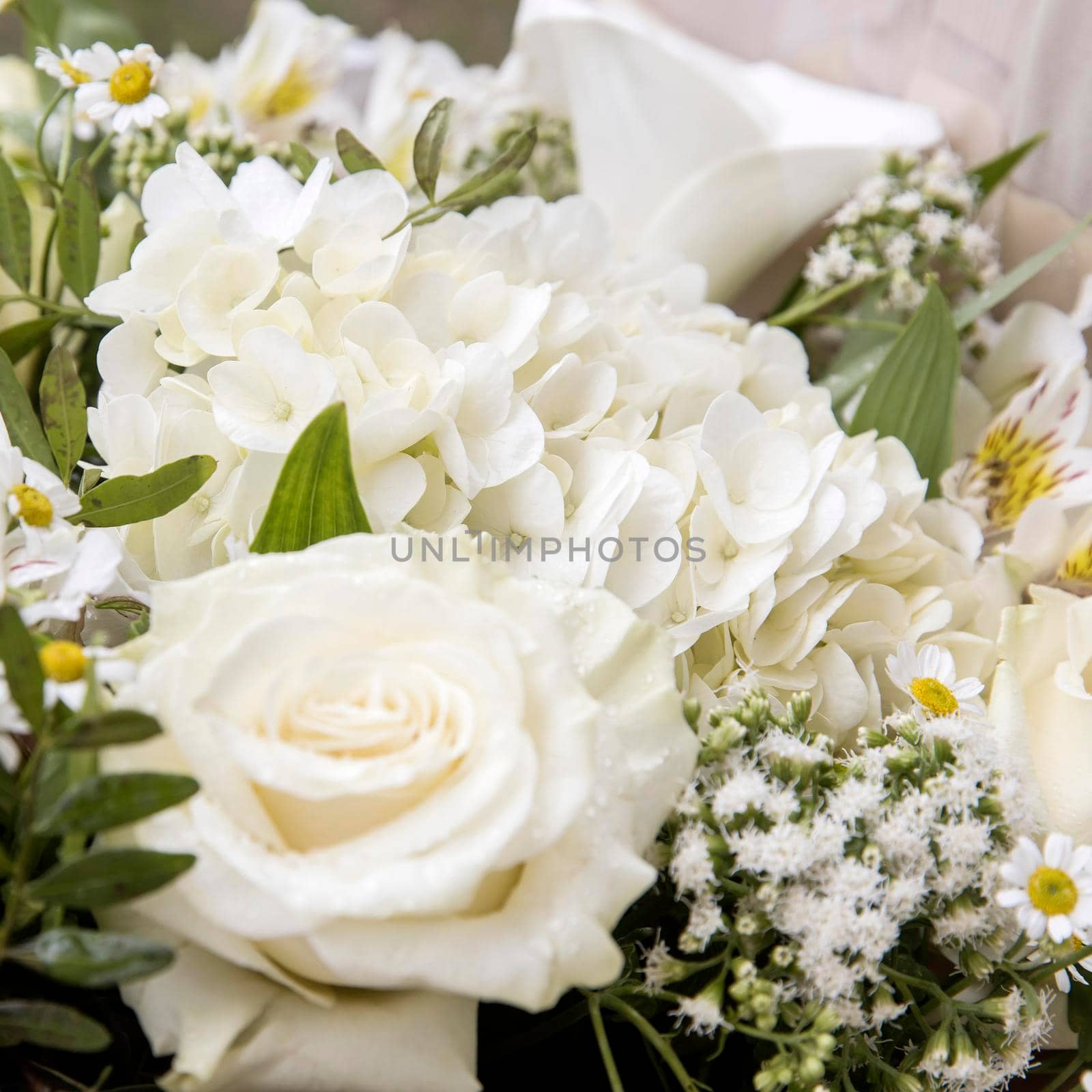 Wedding bouquet of white flowers - roses, hydrangeas, chamomile, wrapped in craft paper by elenarostunova