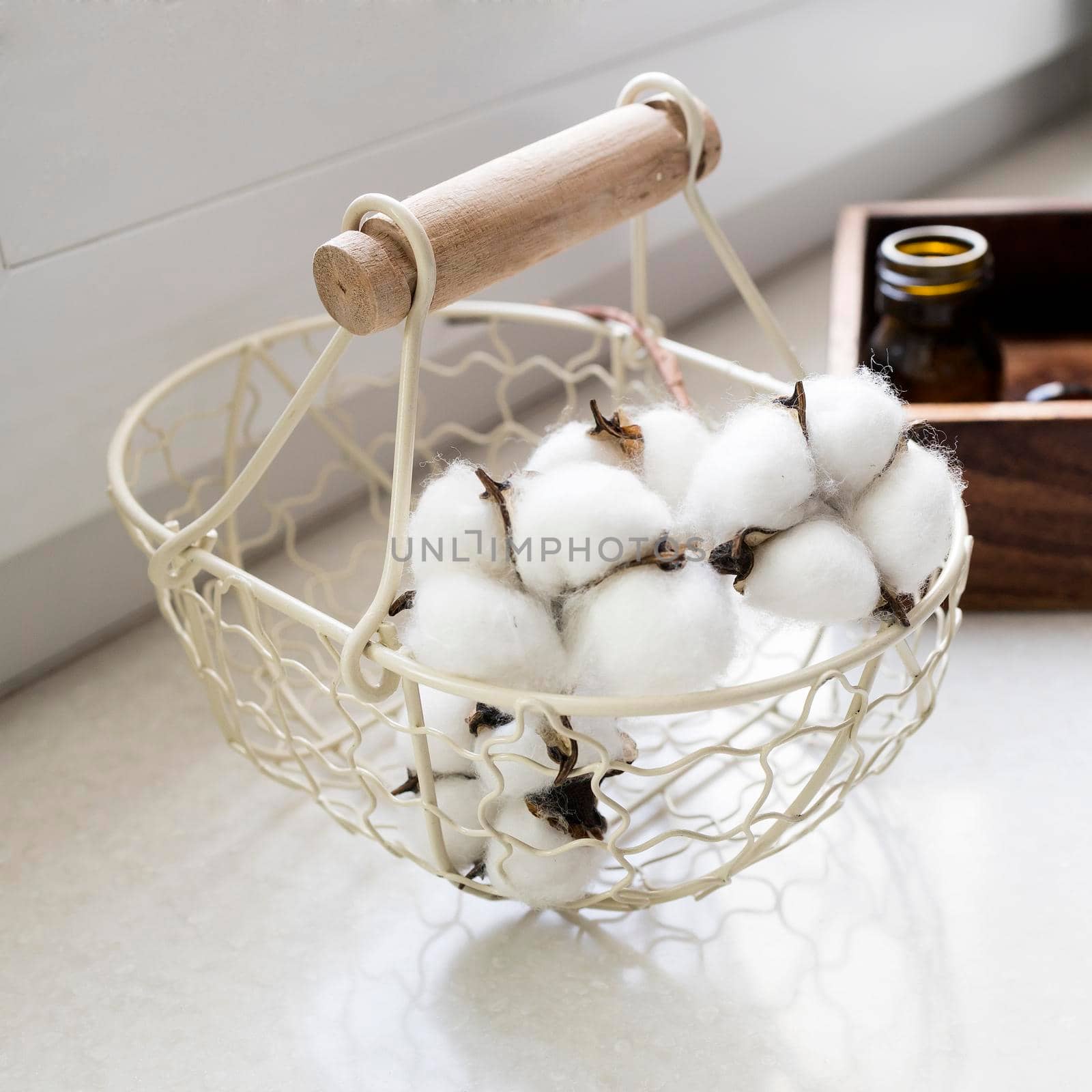 wicker metal basket with cotton flowers inside. by elenarostunova