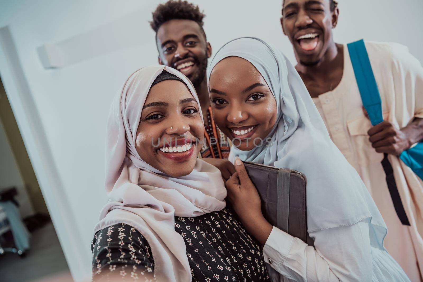 A group of multiethnic students take a selfie with a smartphone on a white background. Selective focus by dotshock