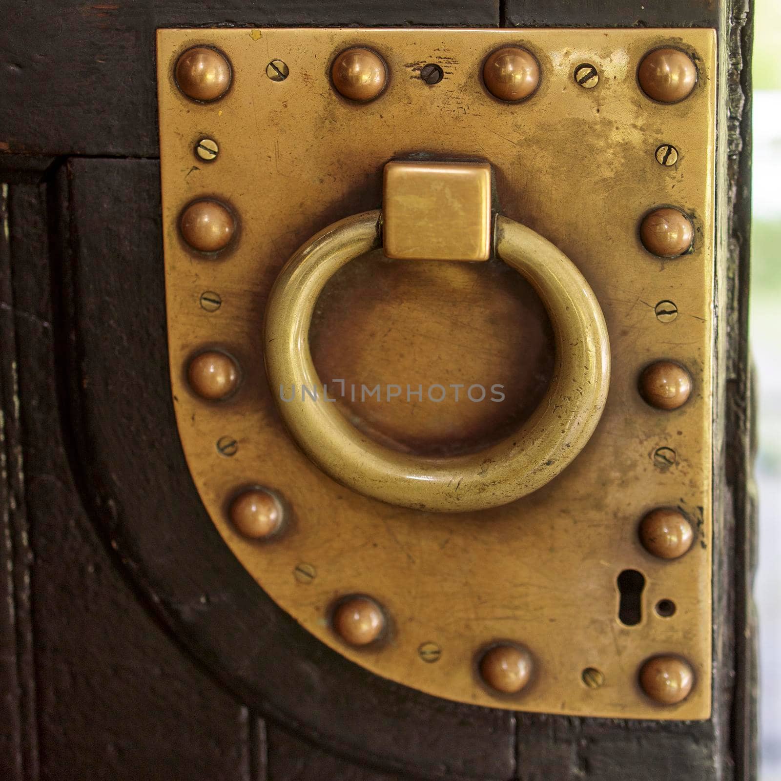 Door handle knocker selective focus on brown old wooden church entrance door front view with copyspace. Square frame