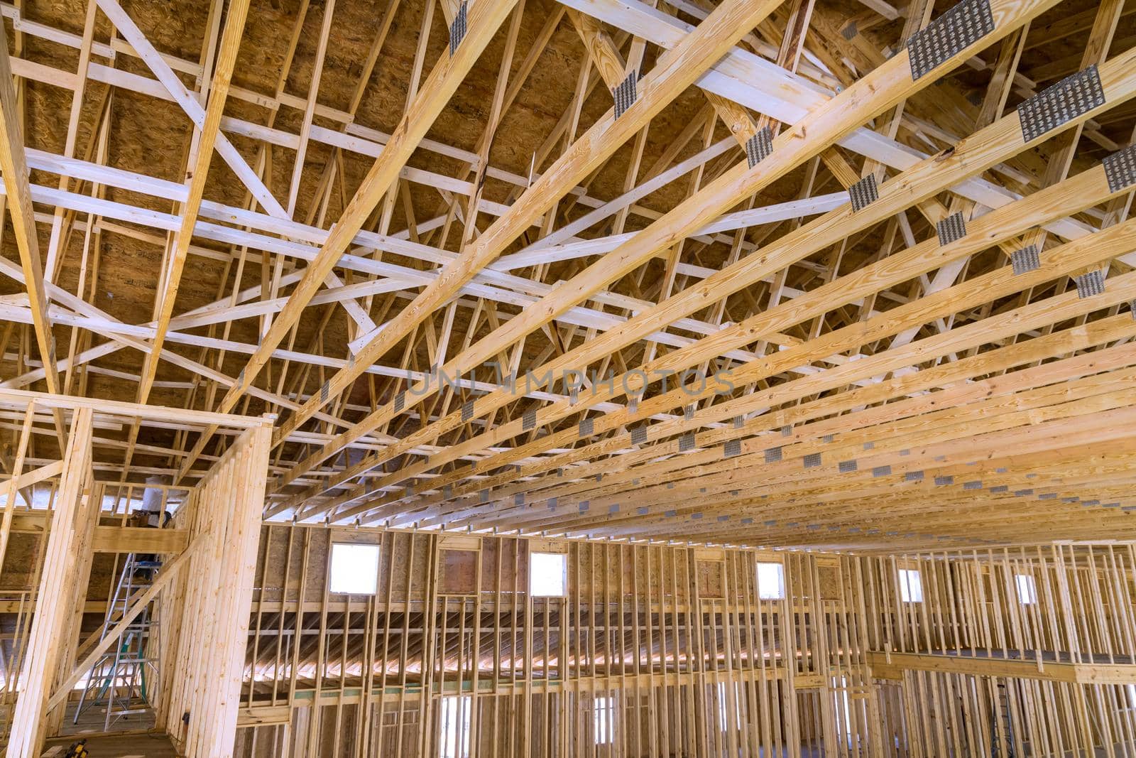 Interior framing of a new house under construction with roof truss system beams built frame