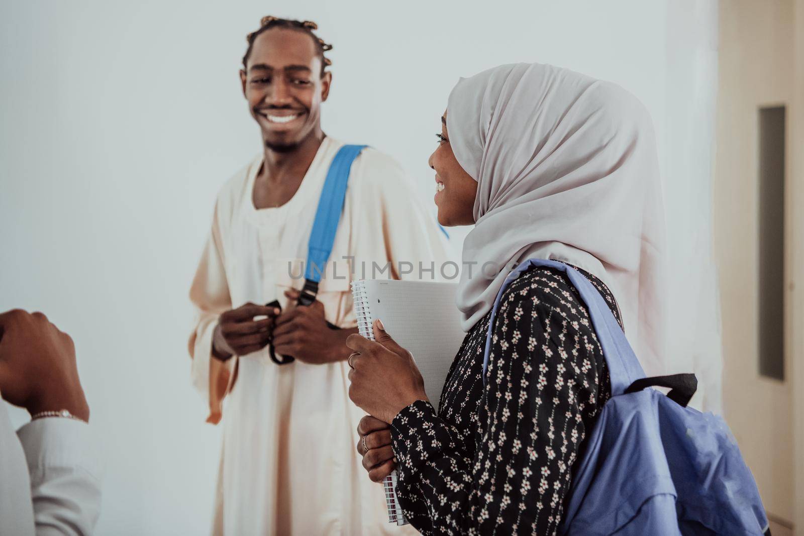 Group of happy african students having conversation and team meeting working together on homework girls wearing traidiional sudan muslim hijab fashion by dotshock