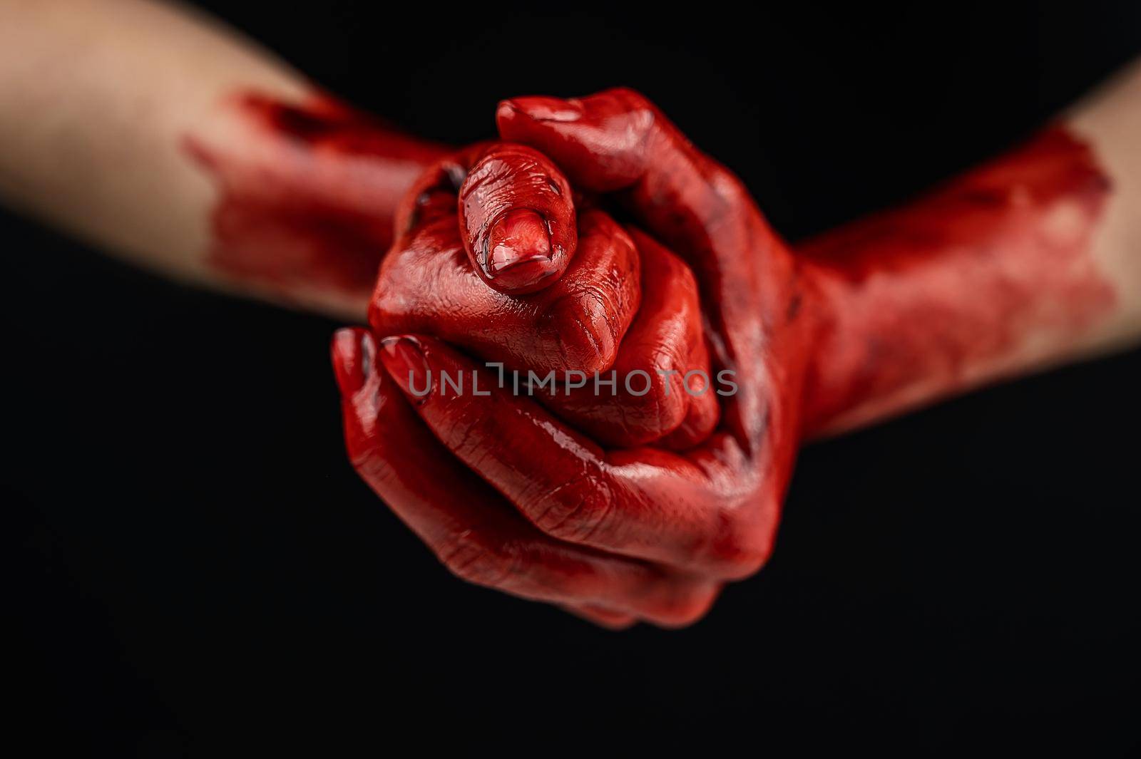 Women's fists in blood on a black background. Fist and palm