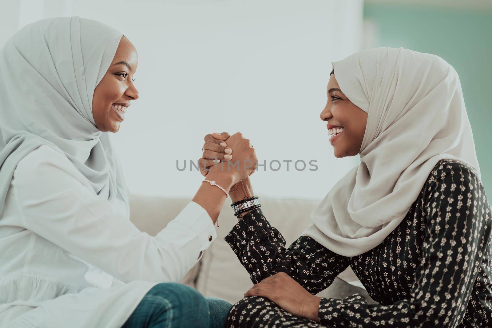 African women arm wrestling conflict concept, disagreement, and confrontation wearing traditional Islamic hijab clothes. Selective focus. High-quality photo