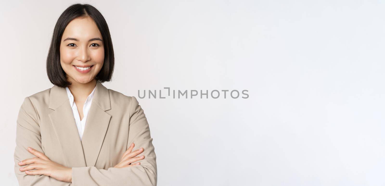 Confident female entrepreneur, asian business woman standing in power pose, professional business person, cross arms on chest, standing over white background.