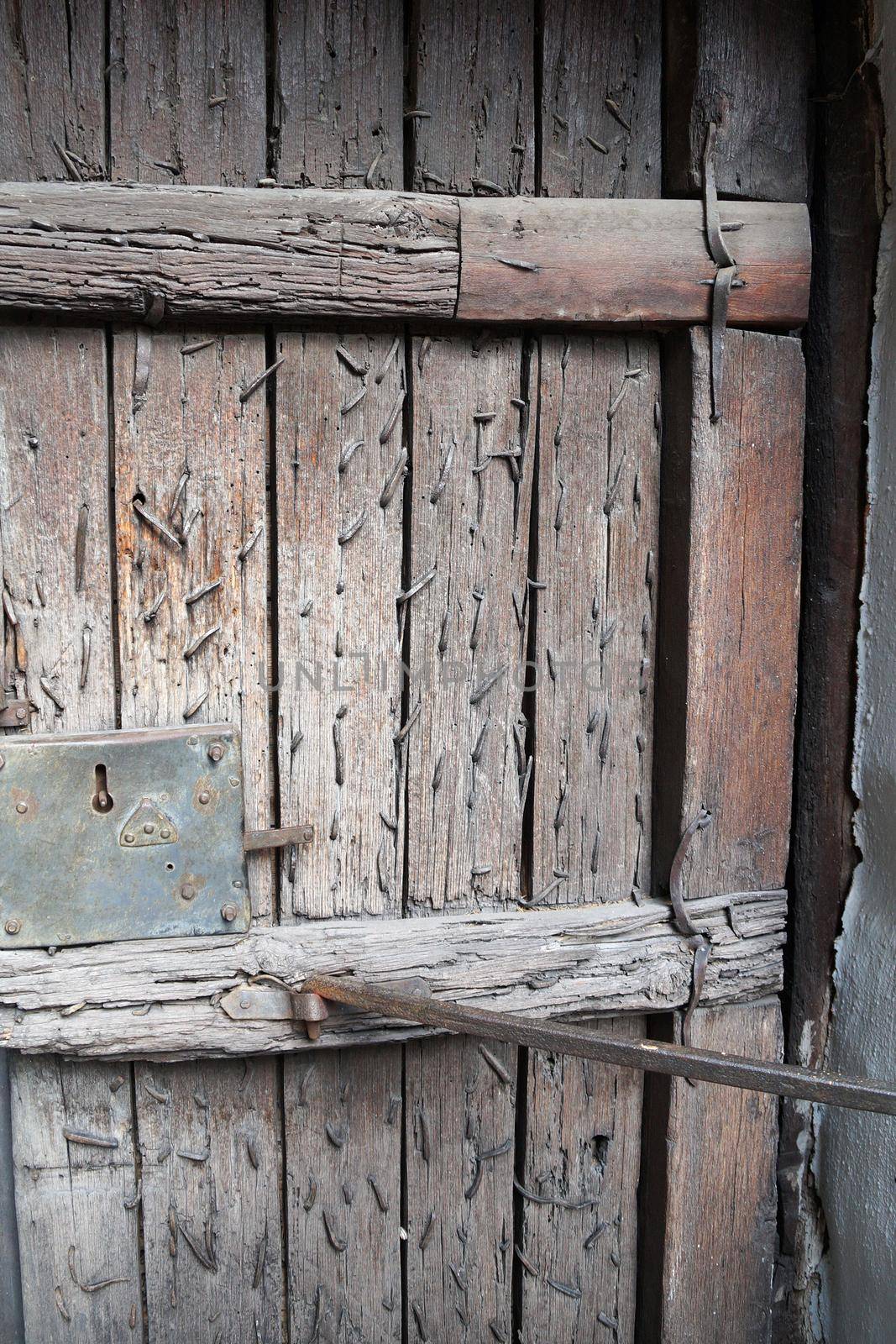 ancient wooden door with many boarded up nails.