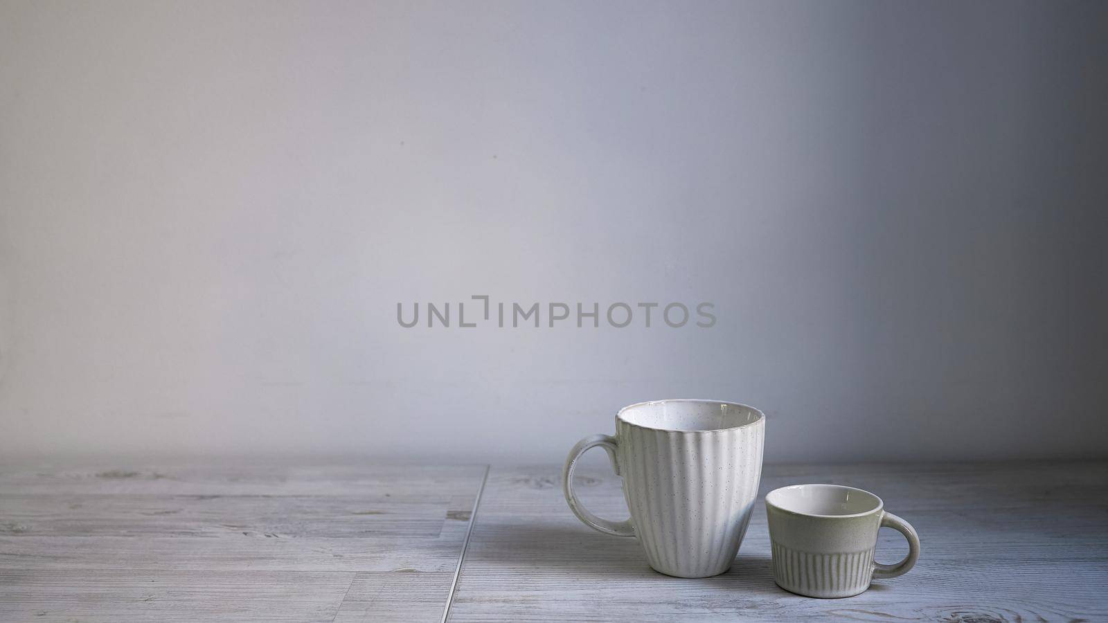 Minimalistic Scandinavian style. Two cups of coffee or tea of different sizes for two on on the table. by elenarostunova