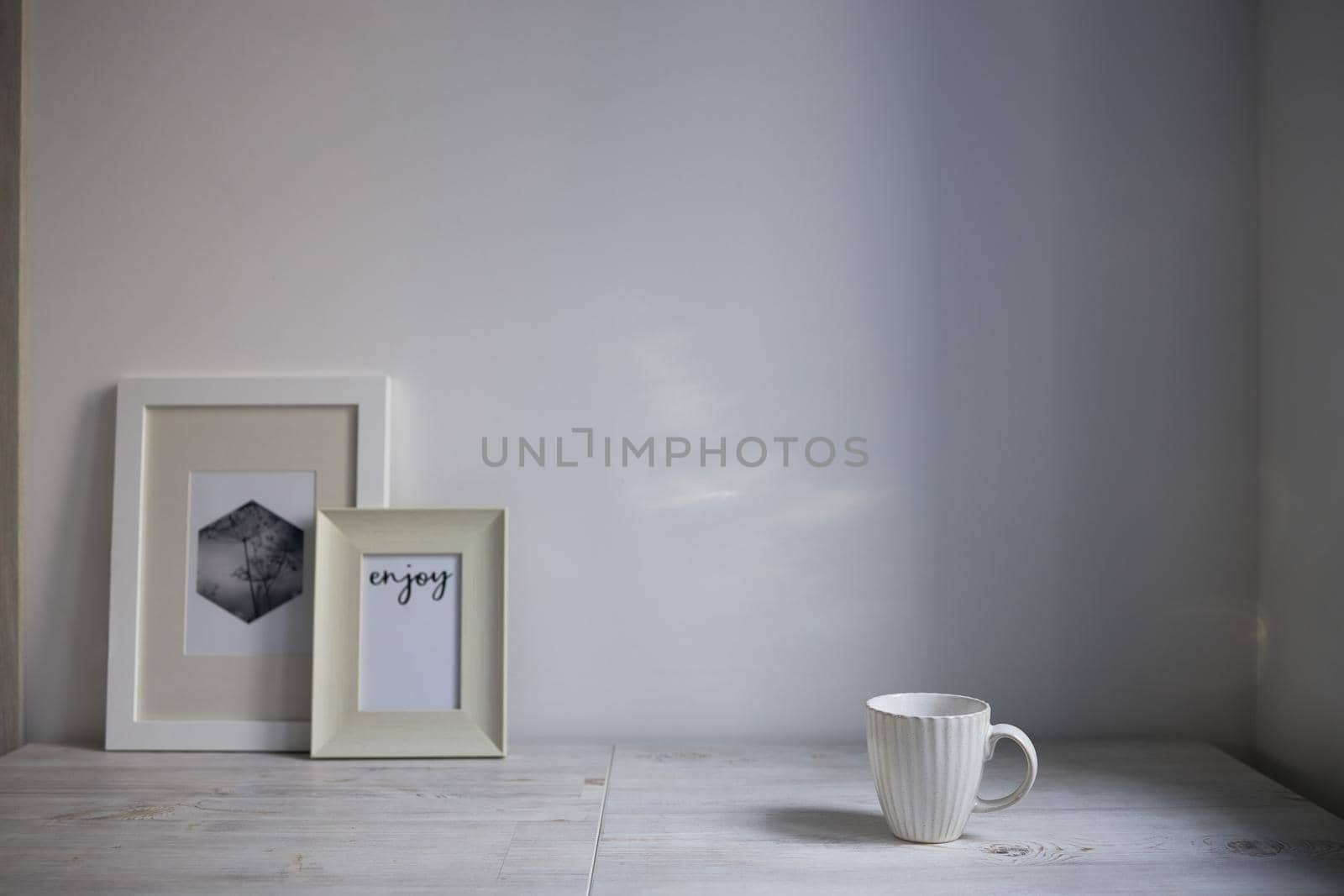 Scandinavian style. Interior Design. A white cup, a two frame for a photo are on the table. Empty space for text