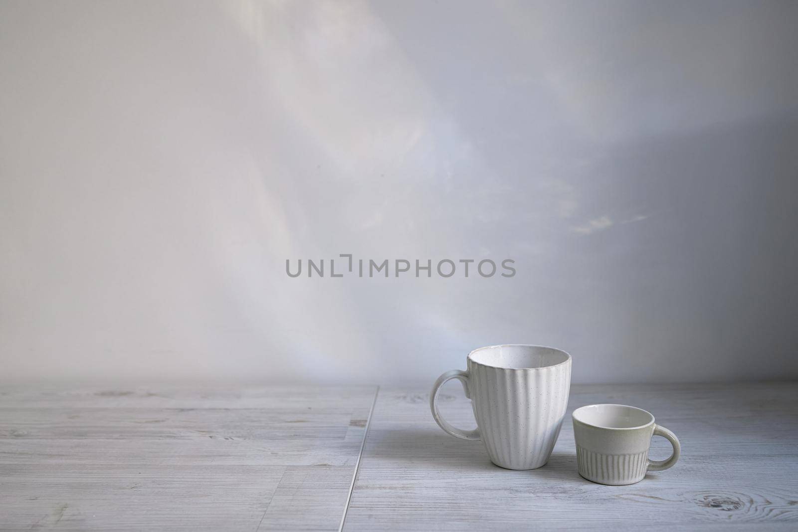 Minimalistic Scandinavian style. Two cups of coffee or tea of different sizes for two on on the table. Empty space.