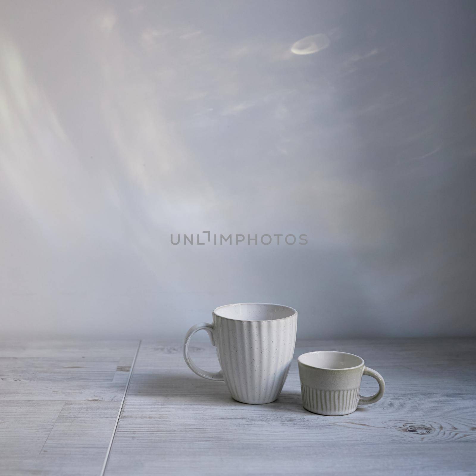 Minimalistic Scandinavian style. Two cups of coffee or tea of different sizes for two on on the table. Empty space. Square frame.