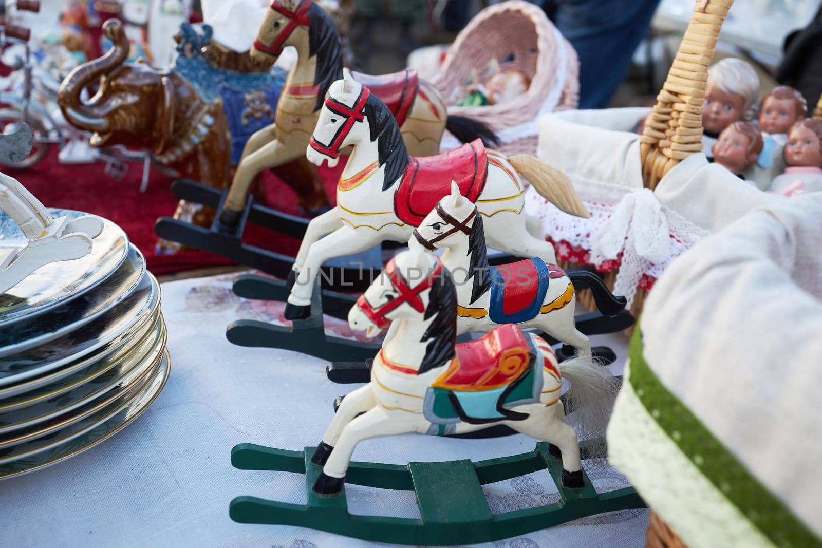 Wooden rocking horse white in red patterns in a row at the flea market at the weekend in the Museum of Moscow by elenarostunova