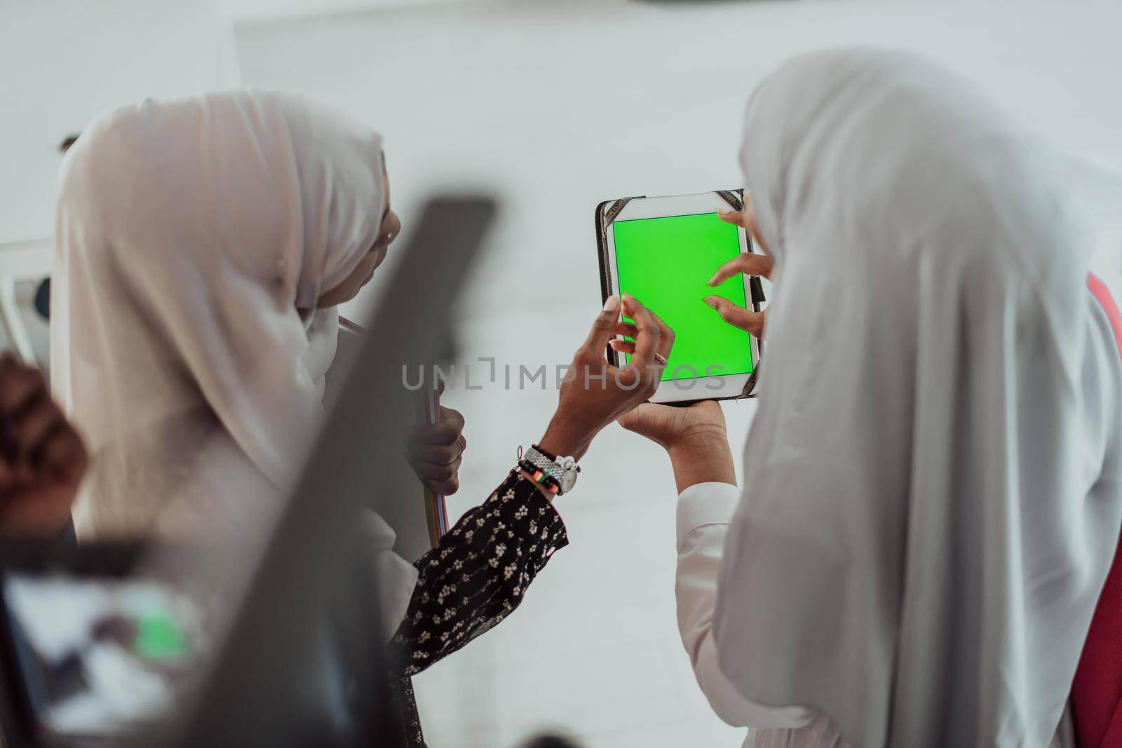 Group of happy african students having conversation and team meeting working together on homework girls wearing traidiional sudan muslim hijab fashion by dotshock
