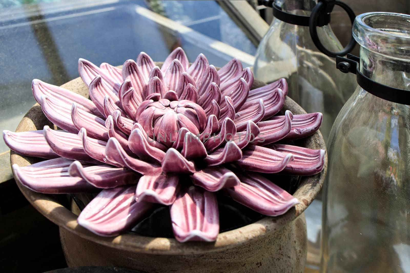 Ceramic figurine purple and pink echeveria in a clay pot as a garden decoration.