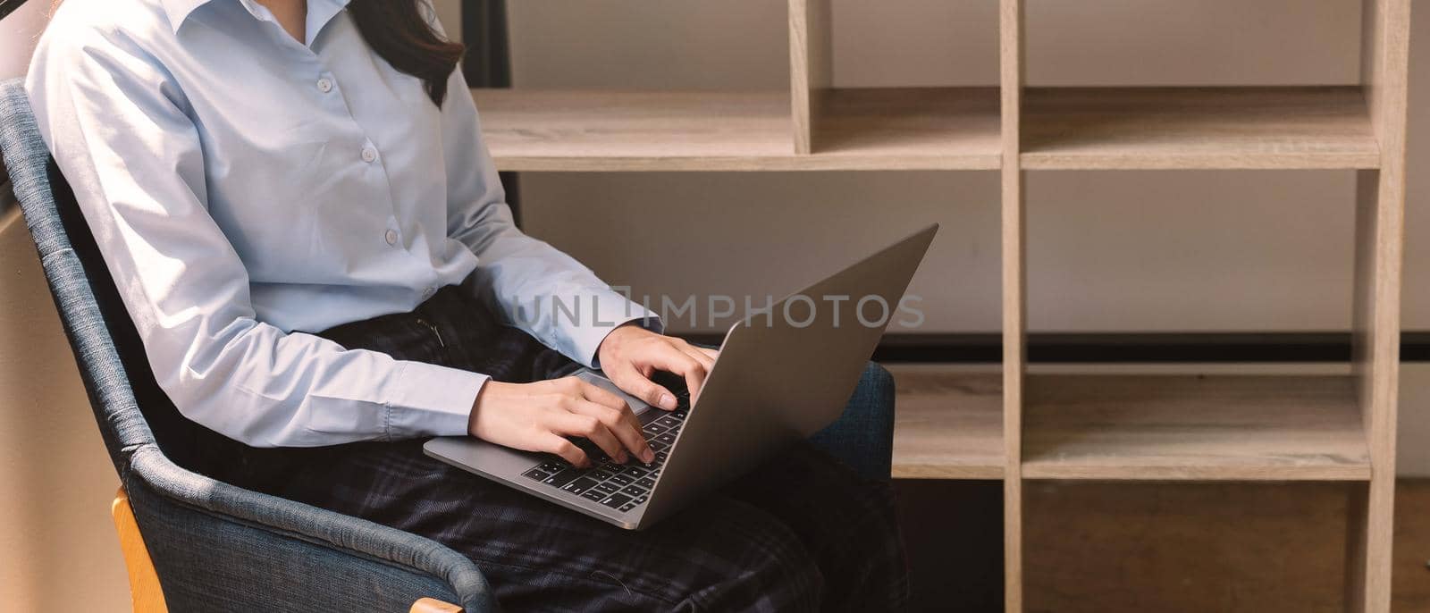 Crop shot of woman using her laptop at home by nateemee