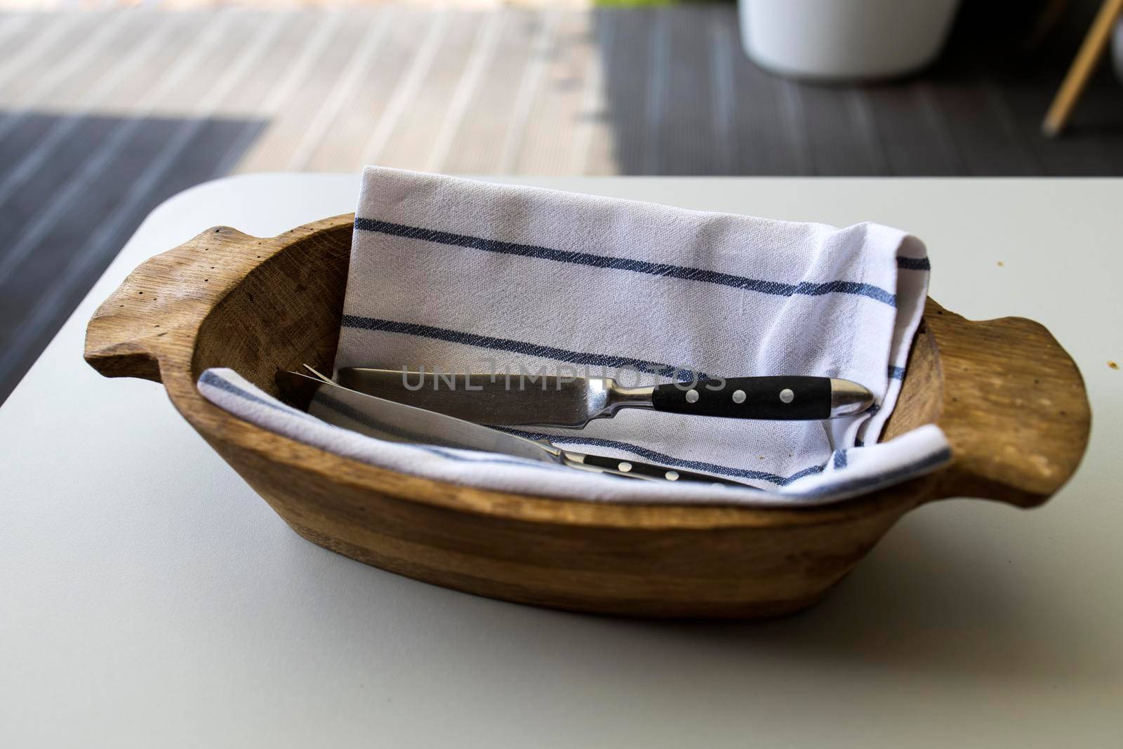 Wooden bowl with a towel inside for cutlery served in the restaurant by elenarostunova
