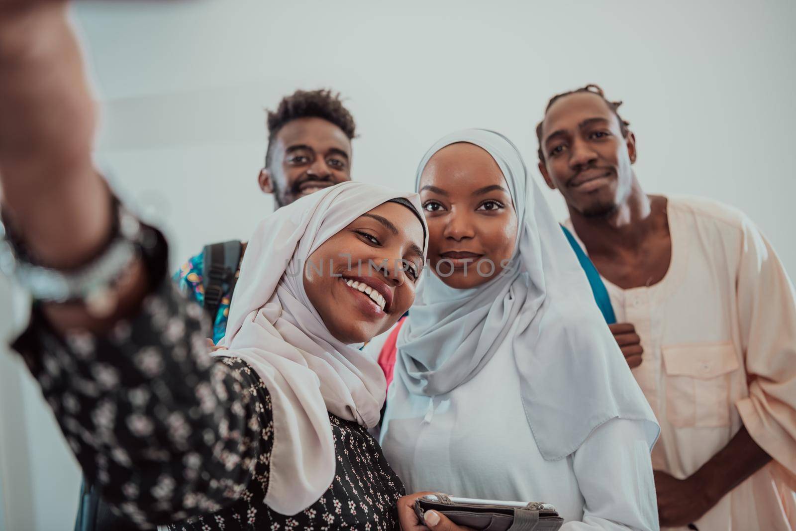 A group of multiethnic students take a selfie with a smartphone on a white background. Selective focus by dotshock