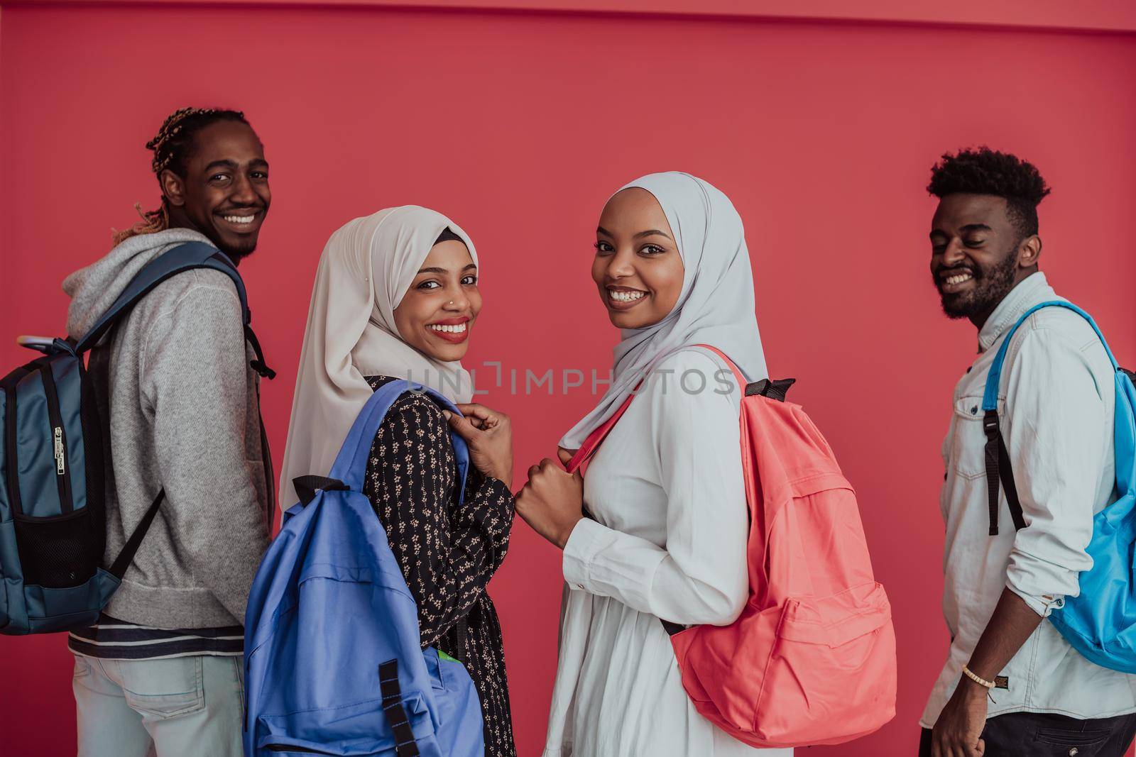 A group of African Muslim students with backpacks posing on a pink background. the concept of school education. High-quality photo