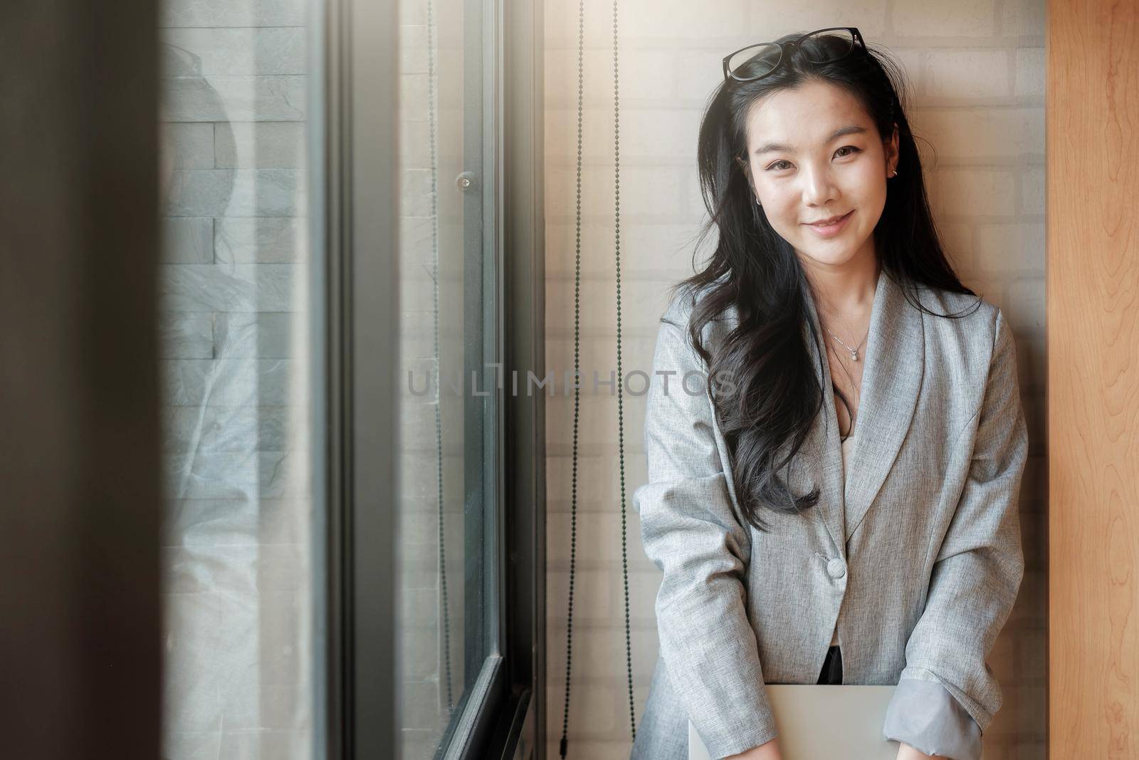 Portrait of smiling millennial businesswoman holding laptop computer looking at camera.