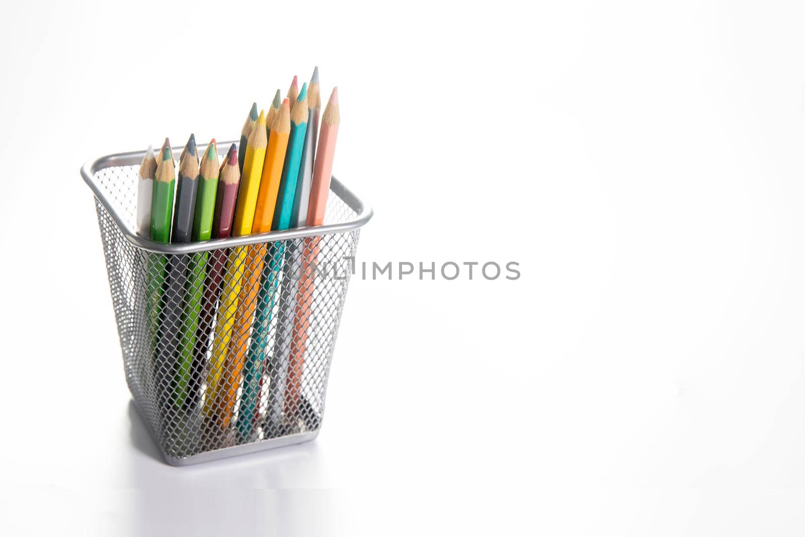 Colored pencils in an iron pencil case isolated on a white background.