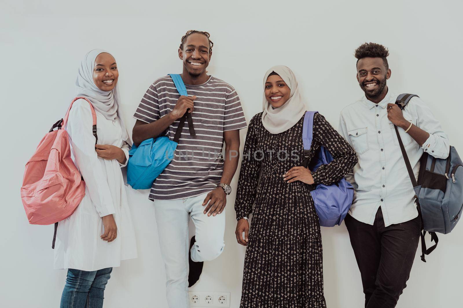 Photo of a group of happy african students talking and meeting together working on homework girls wearing traditional Sudanese Muslim hijab by dotshock