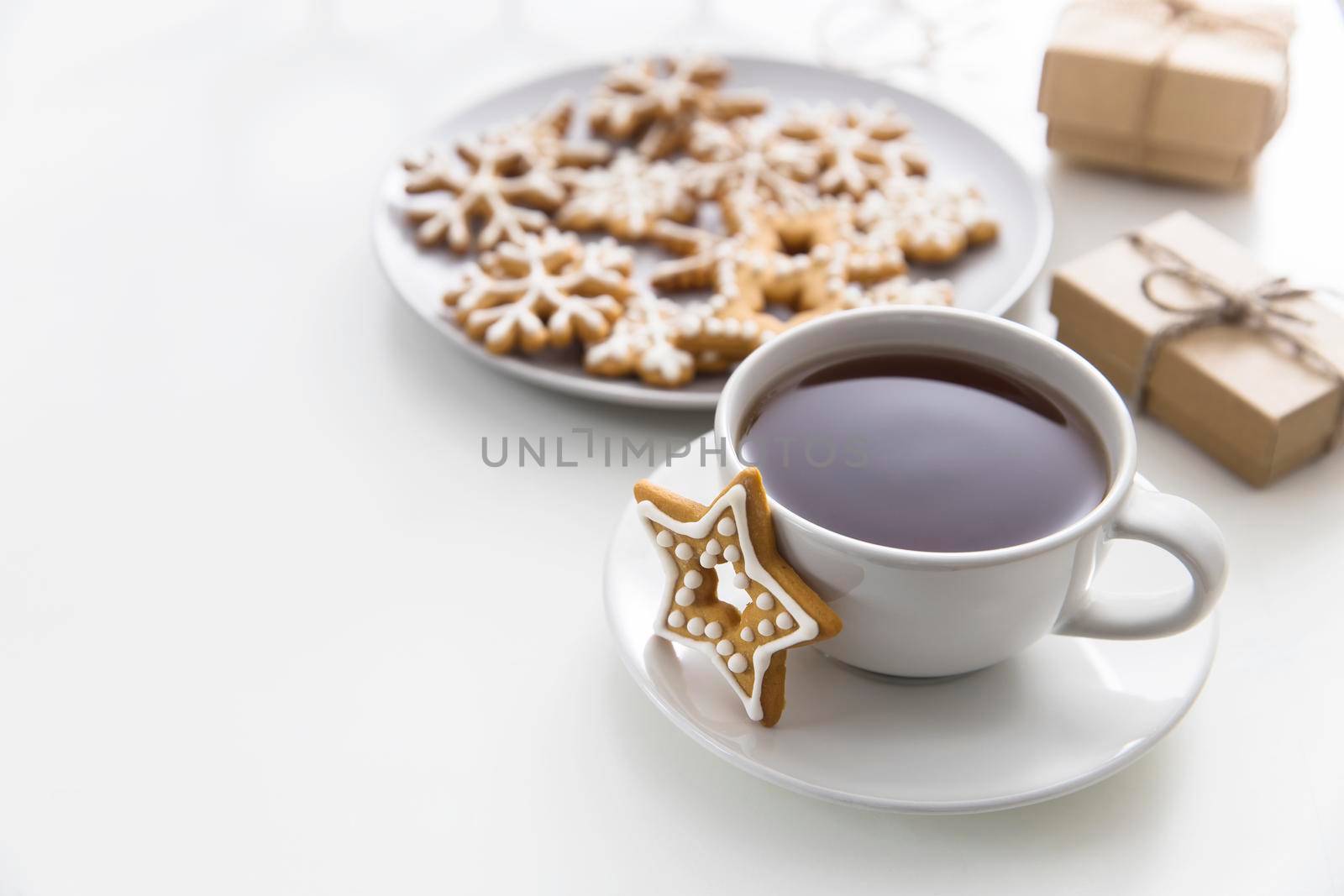 Cup of coffee with gingerbread christmas cookies in the form of stars on a white table. Copy space by elenarostunova