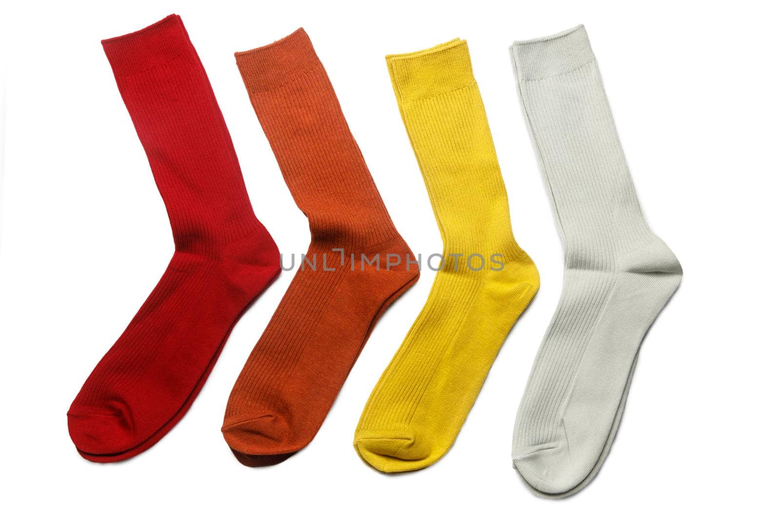 Four pairs of multi-colored socks: yellow, orange, gray, red are on a white background by elenarostunova