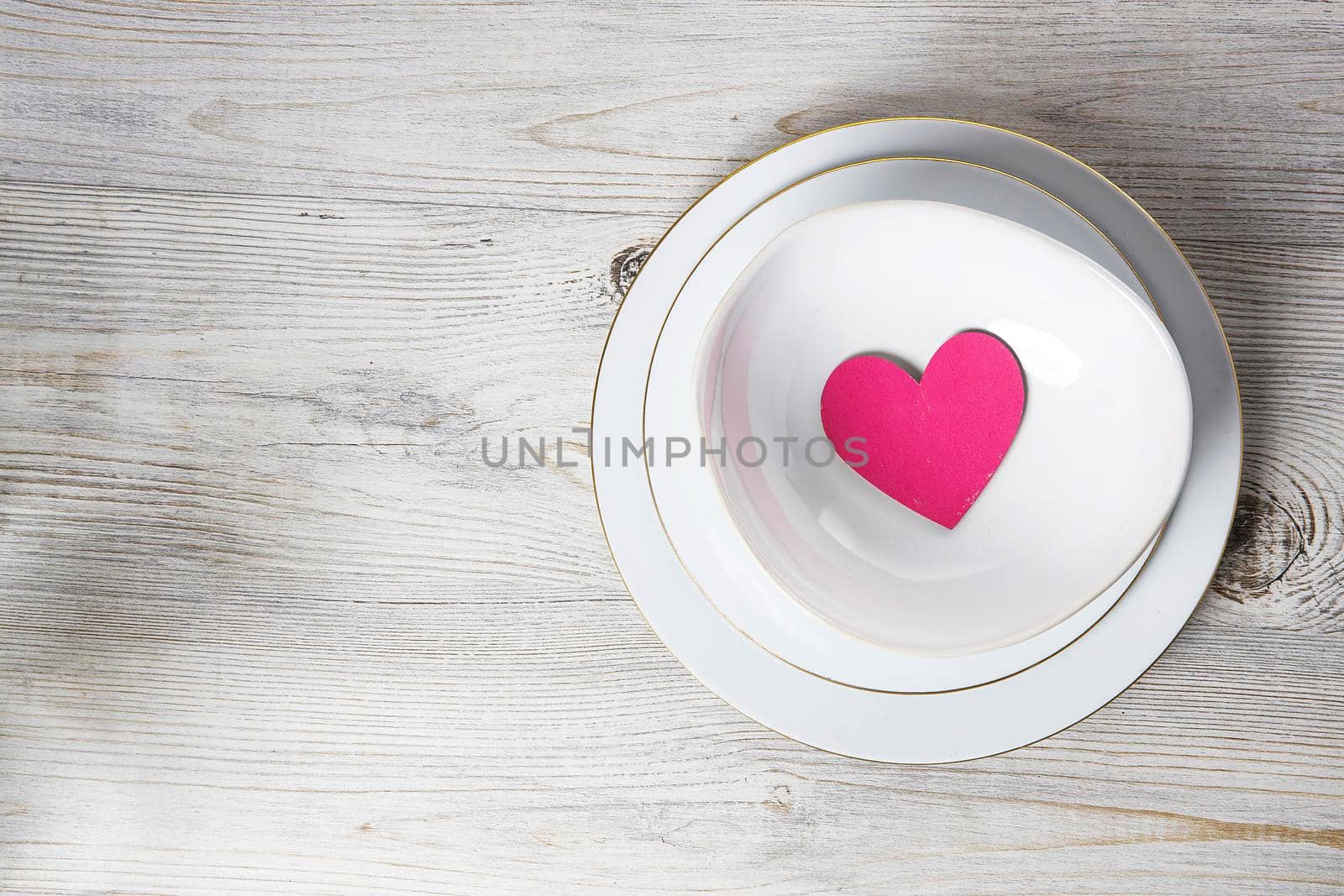 Red wooden hearts in a ceramic bowl filled with paper. Place for your text by elenarostunova