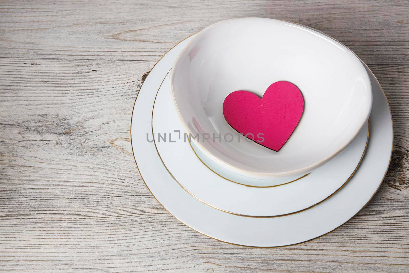 Red wooden hearts in a ceramic bowl filled with paper. Place for your text