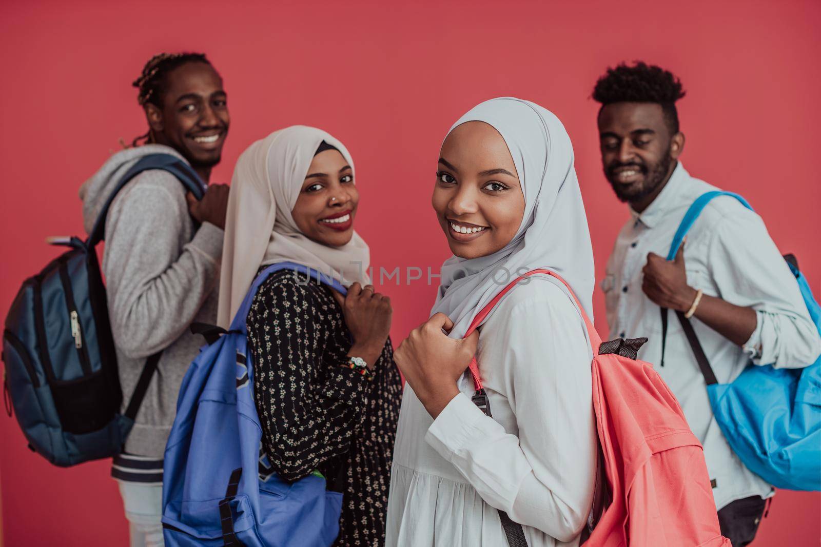 A group of African Muslim students with backpacks posing on a pink background. the concept of school education. by dotshock