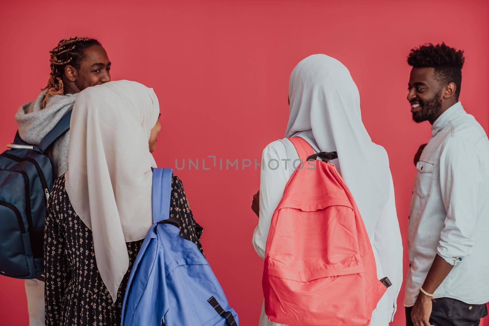 A group of African Muslim students with backpacks posing on a pink background. the concept of school education. High-quality photo