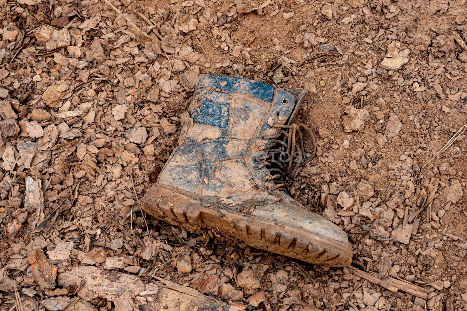 one soldier's boot in the mud. dirty boots on the ground. Losses in battle.