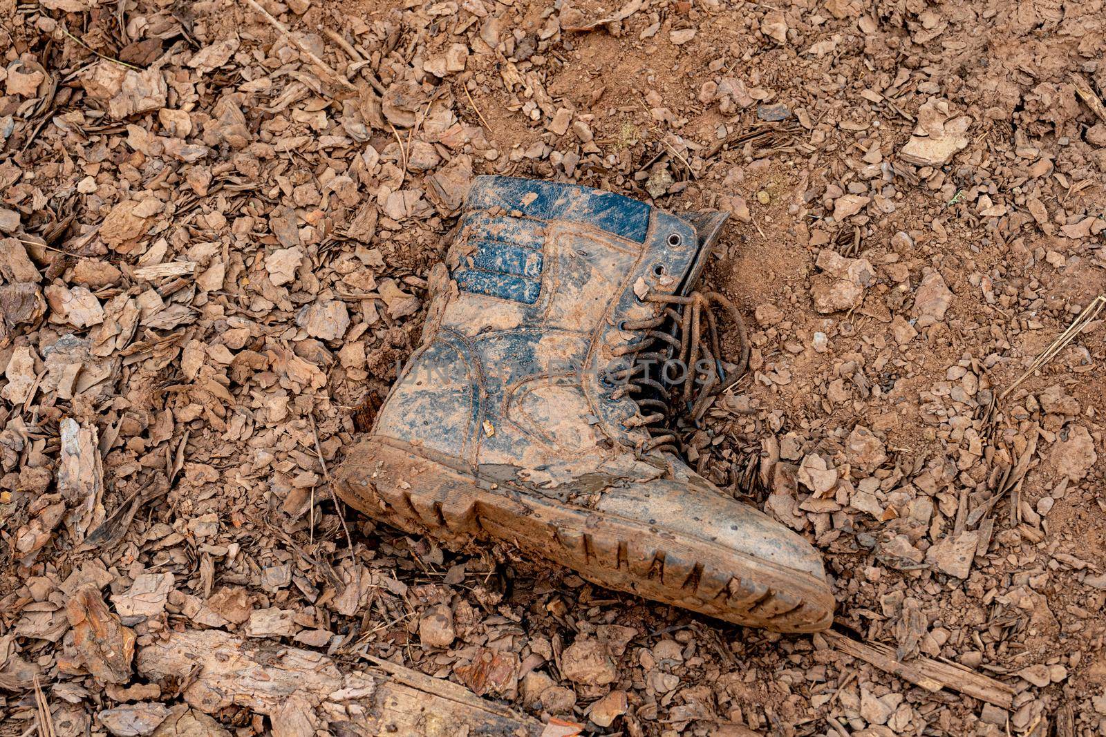 one soldier's boot in the mud. dirty boots on the ground. Losses in battle.