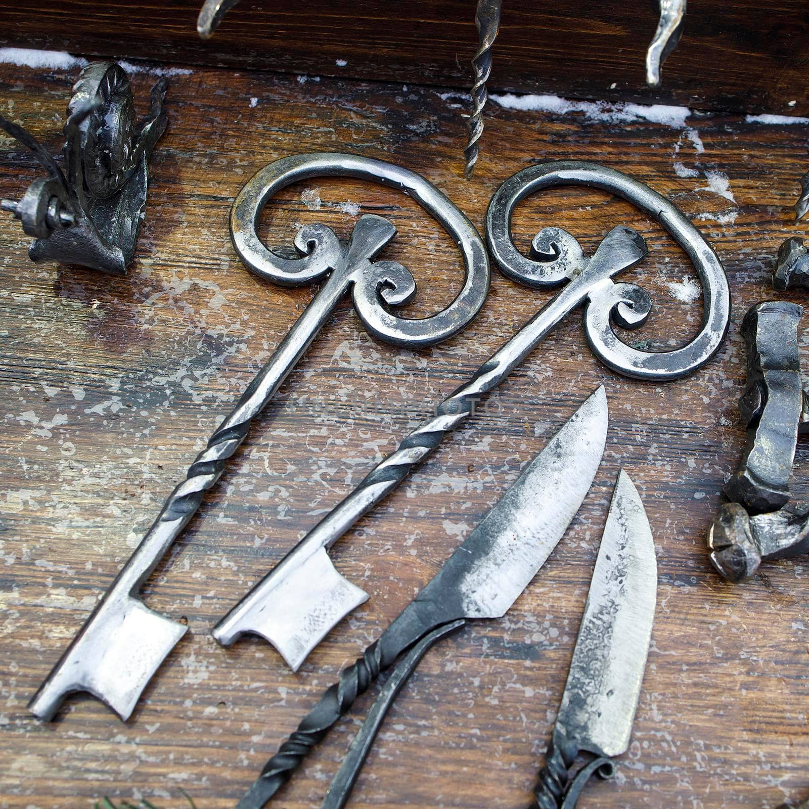 Forged keys and knives are on the counter for sale by elenarostunova