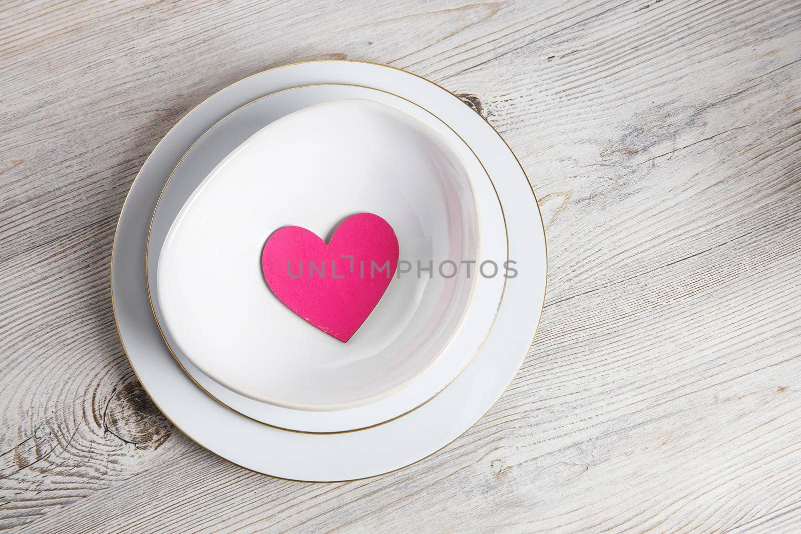 Red wooden hearts in a ceramic bowl filled with paper. Place for your text by elenarostunova