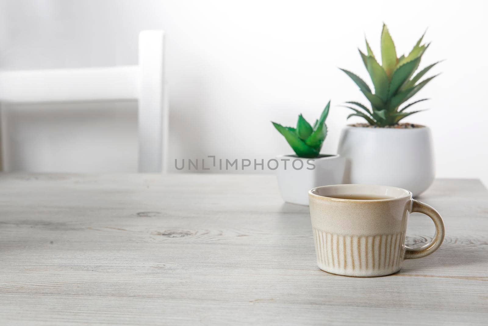 Office desk wood table of the business work place, artificial plants and coffee cup with copy space on grey wooden table. by elenarostunova