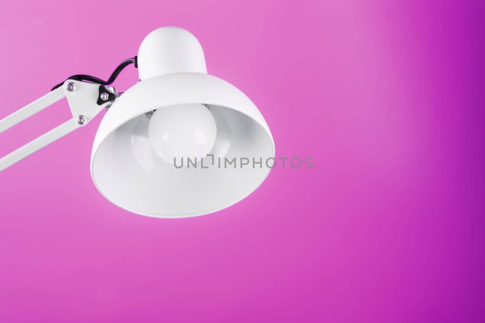 Office table lamp on pink background with space for text and idea concept