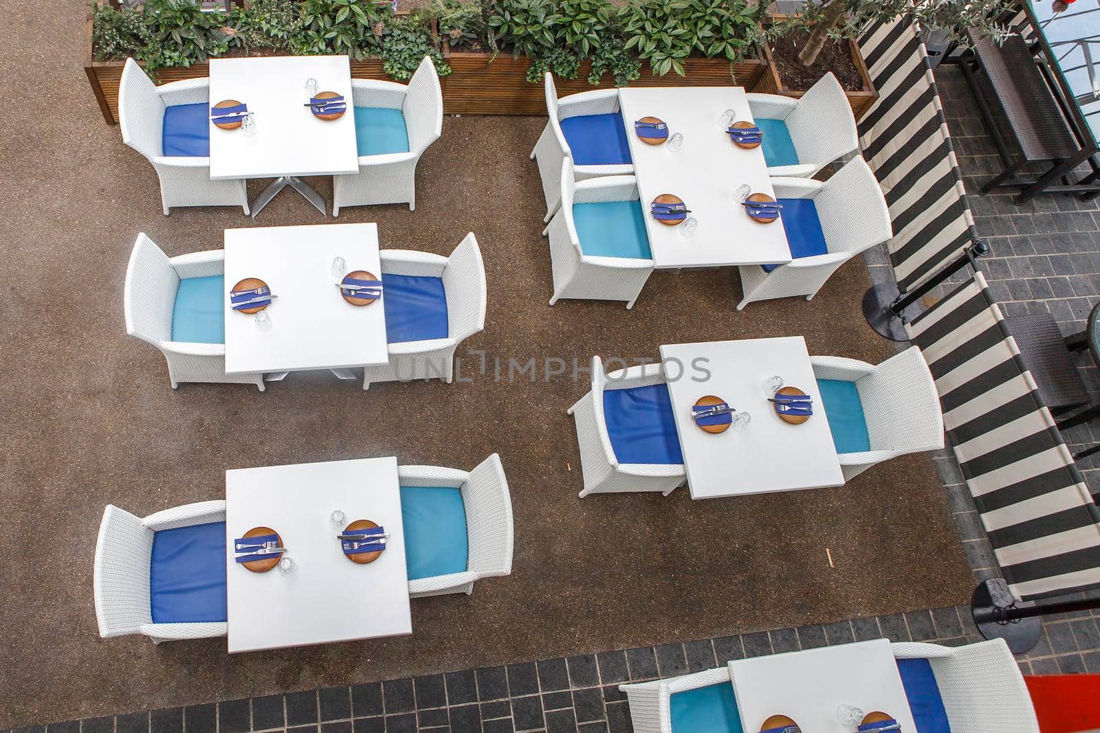 Street cafe, table setting with cutlery items, wicker chairs, top view