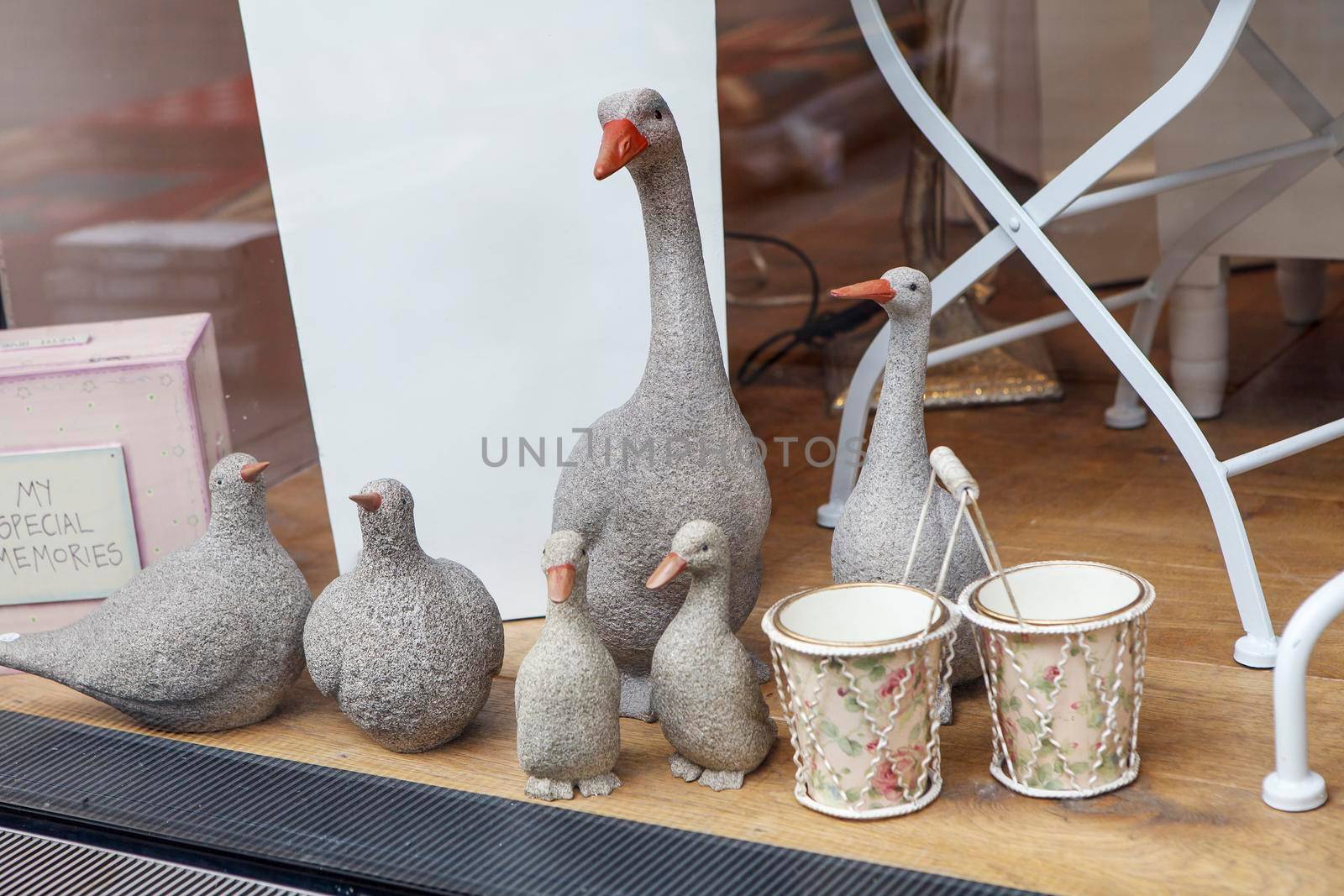 Stone geese and ducks for sale at the entrance to the store by elenarostunova