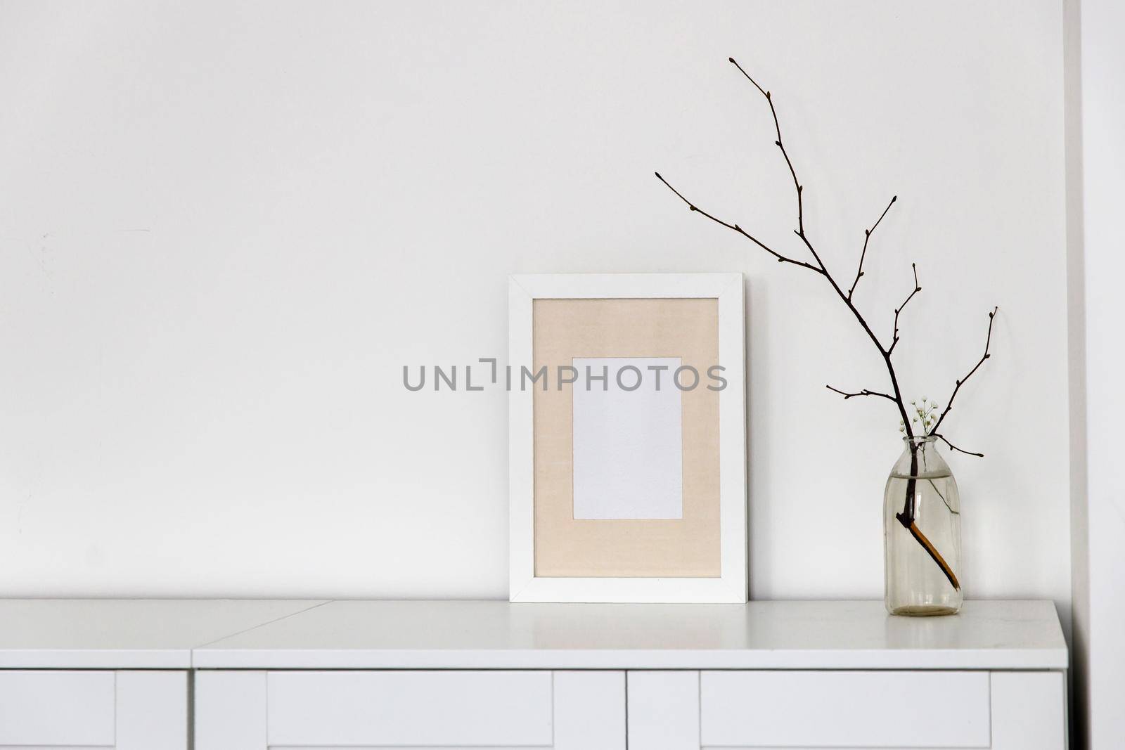 Blank canvas frame mockup. Artwork in interior design. View of modern scandinavian style interior with canvas for painting or poster on wall. Living room, commode with vases. Minimalism concept