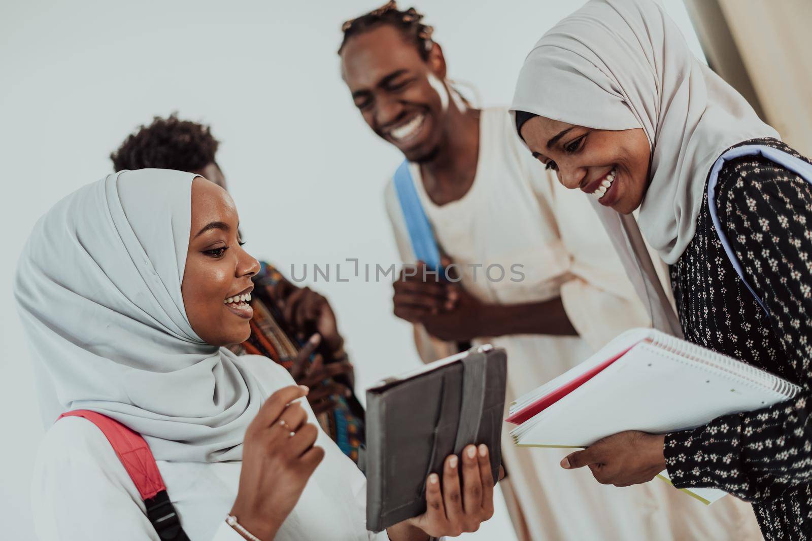 African female student with group of friends in background wearing traditional Islamic hijab clothes. Selectve focus by dotshock