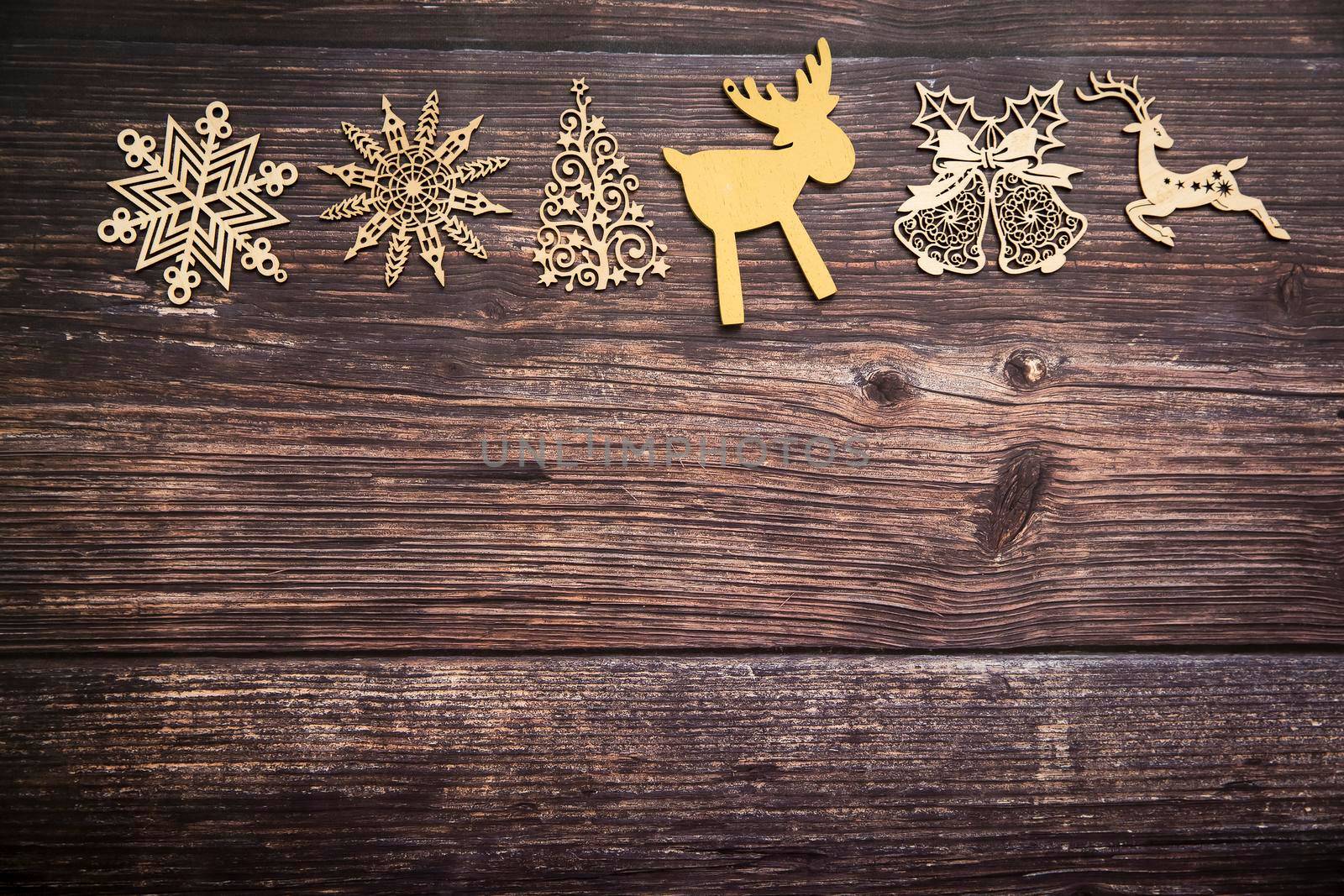 Wooden handmade snowflake toys on dark wooden Christmas background. Crafts cut from eco friendly wood material. Ecological home decor for winter holiday. Copy space. Frame by elenarostunova