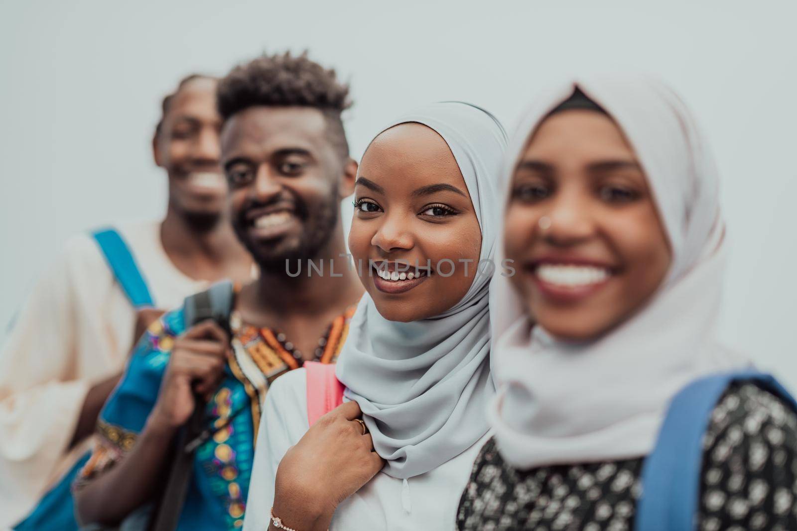 Photo of a group of happy african students talking and meeting together working on homework girls wearing traditional Sudanese Muslim hijab by dotshock