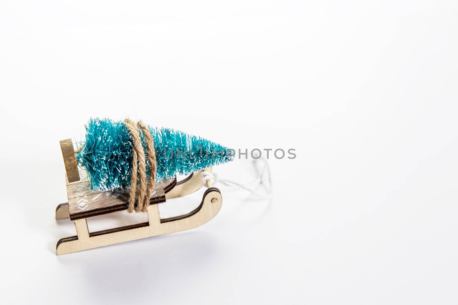 Wooden sleigh with decorative fir tree on white background. Christmas holidays. Copy space. Place for text. Card