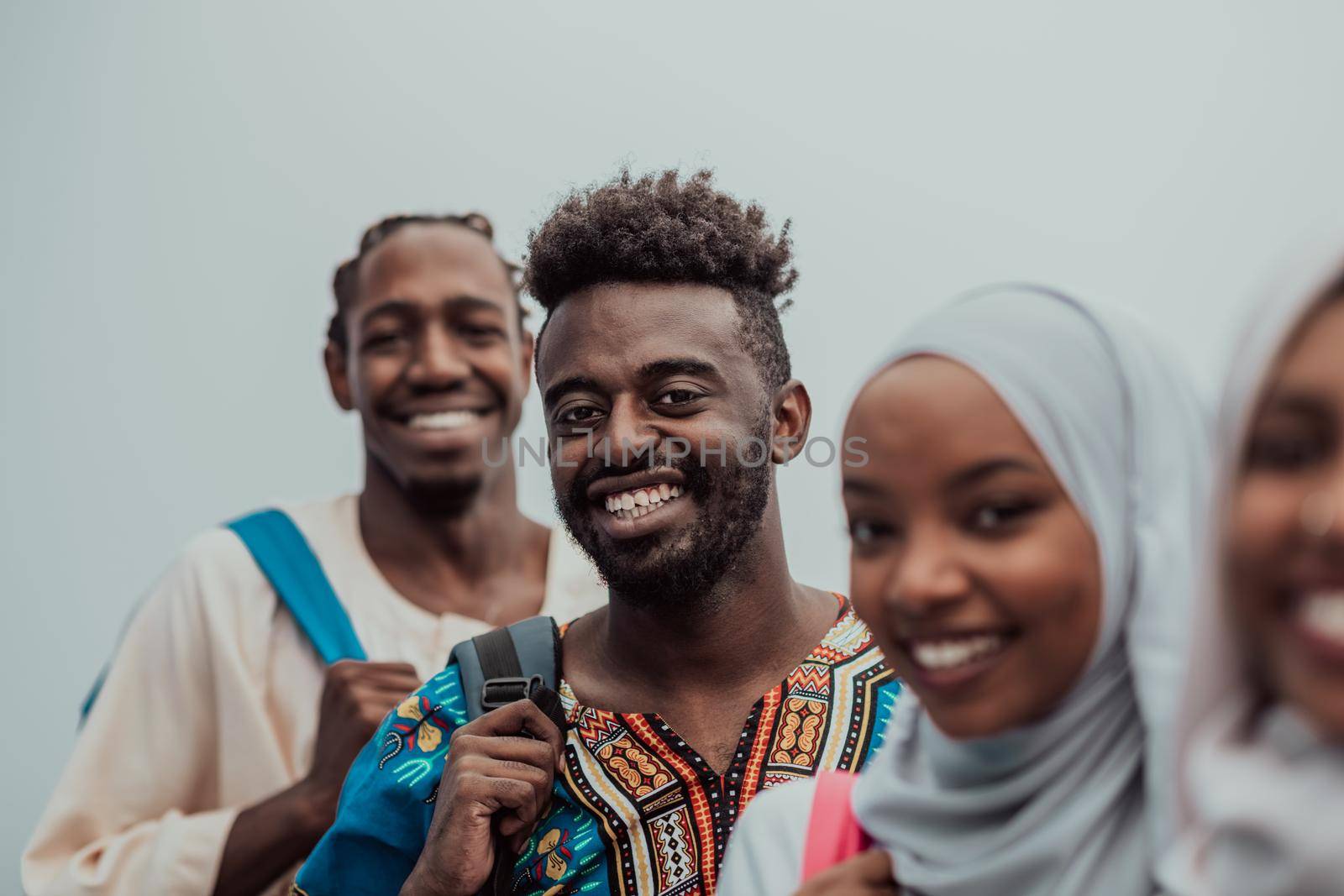 Photo of a group of happy african students talking and meeting together working on homework girls wearing traditional Sudanese Muslim hijab by dotshock