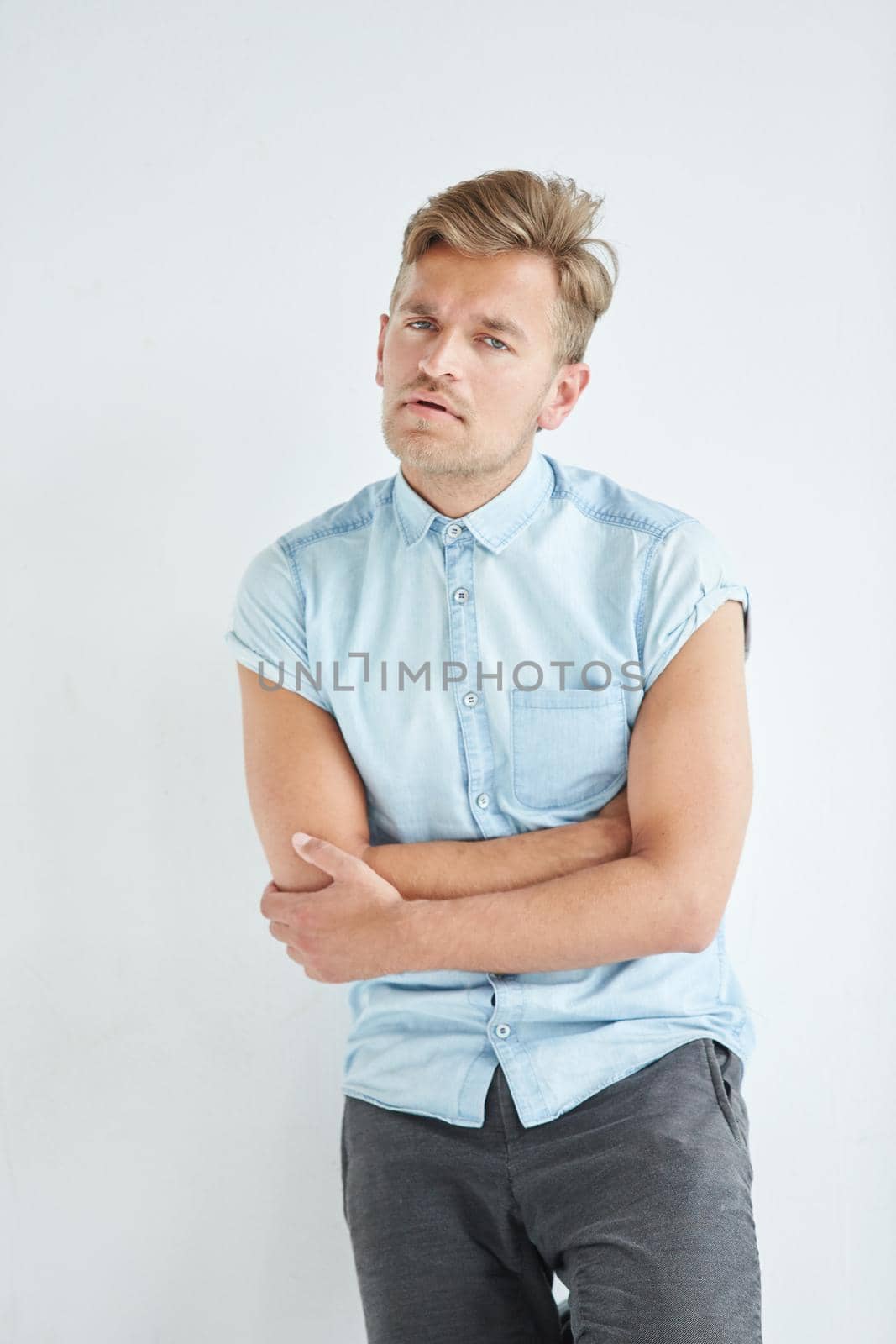 Brutal man in a shirt with short sleeves , his fists clenched, slightly bent, under the gaze of the forehead. High quality photo