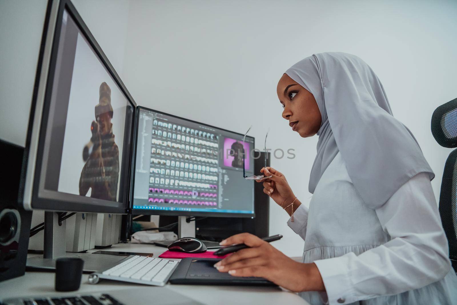 Young Afro-American modern Muslim businesswoman wearing a scarf in a creative bright office workplace with a big screen. High-quality photo