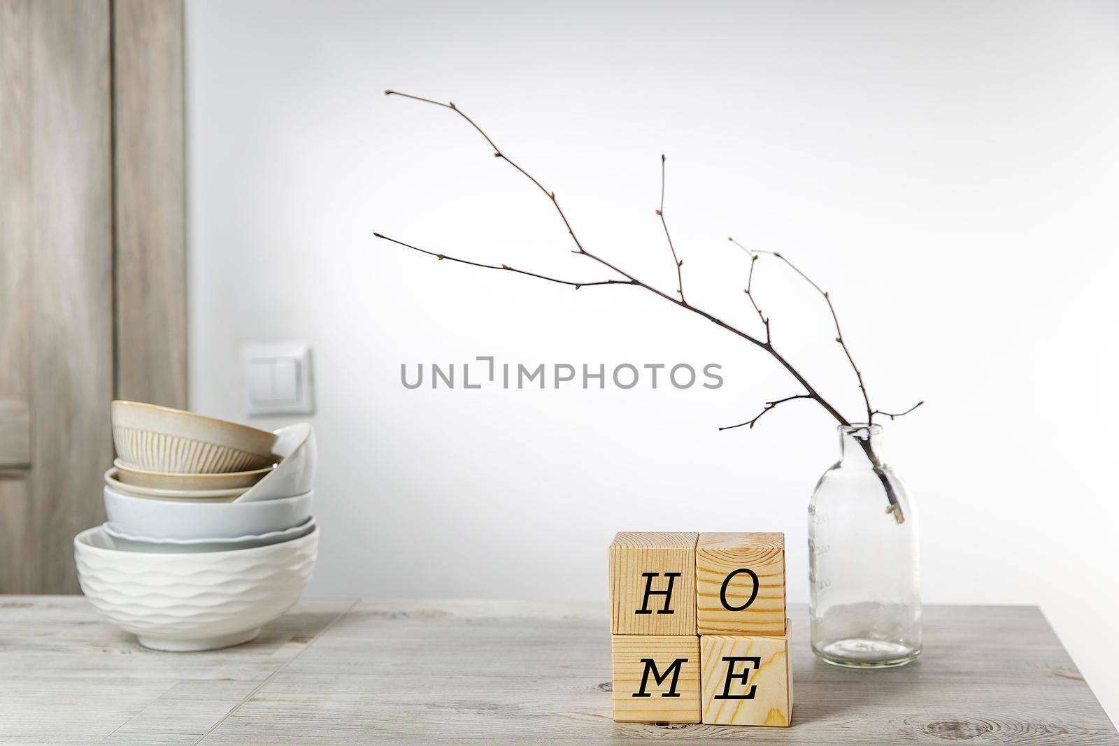 An unblown linden branch in a glass vase and four wooden cubes with space for text. Scandinavian style. Copy text