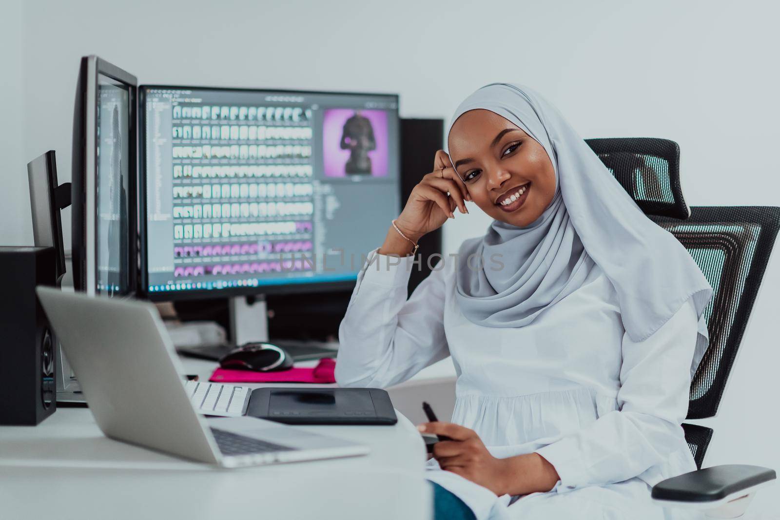 Young Afro-American modern Muslim businesswoman wearing a scarf in a creative bright office workplace with a big screen. High-quality photo