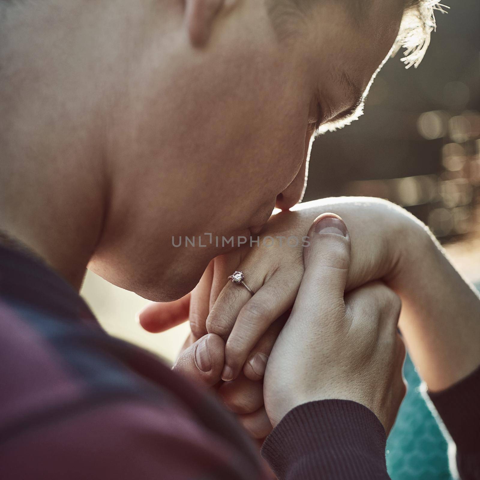 Give me your hand and Ill never let go. Shot of a young man affectionately kissing his girlfriends hand outdoors. by YuriArcurs